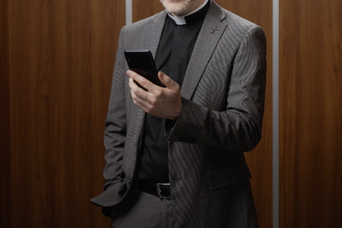 Sacerdote con su celular en redes sociales