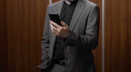 Sacerdote con su celular en redes sociales