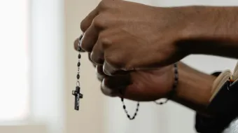 Imagen referencial de una mujer rezando el Rosario