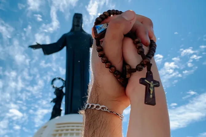 Una pareja sostiene un rosario ante la imagen de Cristo Rey en el Cerro del Cubilete (México).