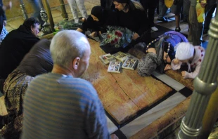 Peregrinos realizan prácticas devotas en la basílica del Santo Sepulcro en Jerusalén. Crédito: Julio Martinich (CC BY-NC-ND 2.0 DEED).