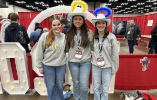 Lucy Snipes, Anne Young y Presley Hilderbrand, de Columbus, Georgia (Estados Unidos), recorren las exposiciones durante la primera noche del NCYC 2025, el 20 de noviembre de 2025, en el Indiana Convention Center en Indianápolis. Crédito: Tessa Gervasini / CNA.