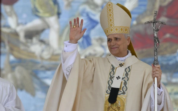 El Papa León XIV saluda durante la Misa de inauguración de su pontificado, celebrada en la Plaza de San Pedro el 18 de mayo de 2025. Se encuentra frente a un tapiz flamenco que representa el diálogo entre Jesús y Pedro tras la pesca milagrosa. Crédito: Vatican Media.