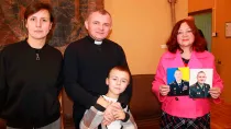 El P. Andrzej, capellán militar, con Olha (izquierda), su hijo de 6 años, y Nadiya (derecha).